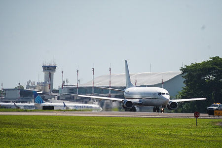 View of a plane carrying Venezuelan migrants that were jailed in El Salvador's Terrorism Confinement Center (CECOT), as it prepares to depart for Venezuela at the San Oscar Romero International Airport in San Luis Talpa, operated by an Avior Airlines flight and a Transmandu Airline registered as YV-657T.