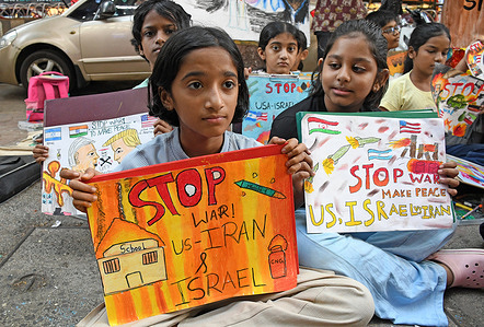 Young students from Gurukul school of art are seen holding painted placards urging to stop the ongoing war between US-Iran-Israel outside their art school in Mumbai.