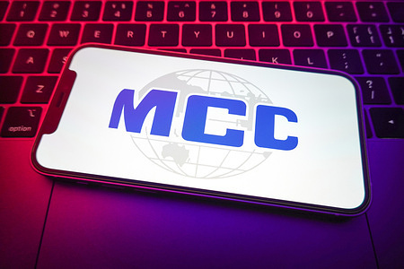 In this photo illustration, MCC logo seen displayed on a smartphone screen.