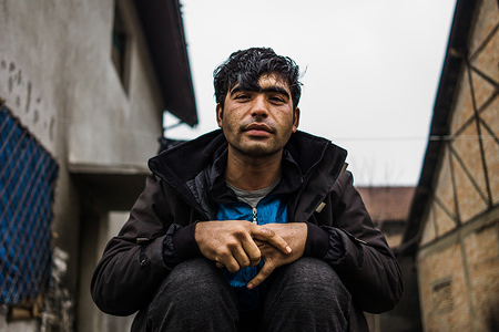 A man sits outside the warehouses in Belgrade that host up to 1500 refugees and migrants.
Behind the bus station in the centre of Belgrade sits a set of abandoned warehouses that host up to 1500 refugees and migrants. With the Balkan route effectively closed, with the exception of a few women and children, the demographic of refugees stranded in Serbia is becoming increasingly dominated by young males. The warehouses have provided a refuge for those staying there but at a cost to their health. To stay warm, many fire are burning throughout the day creating a toxic atmosphere inside the buildings. There are restrictions on the times, types and amounts of aid that can be distributed throughout the city creating problems for the NGO's trying to work there. A major issue encountered by MSF (Medecins sans Frontieres) is recurrent infection of scabies due to people needing to huddle together for warmth.