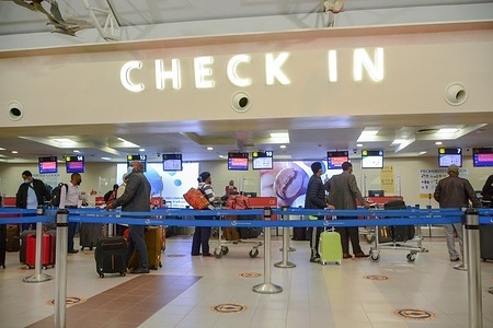 Passengers in facemasks queue at a check-in point at Jomo Kenyatta International Airport awaiting clearance. Kenya Airways has resumed international flights following the easing of travel restrictions by President Uhuru Kenyatta. The flights had been stopped during the Coronavirus pandemic outbreak in the country.
