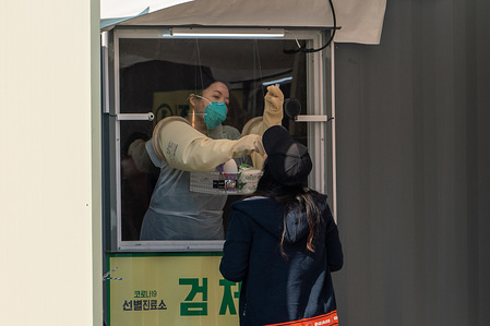 A medical staff wearing a protective suit as a preventive measure, collects samples from a resident at the 'Walk Thru' centre.
The Seoul government opened a 'Walk Thru' centre testing for corona virus cases only for residents in Seoul coming from abroad in response to the global coronavirus(COVID-19) pandemic.
