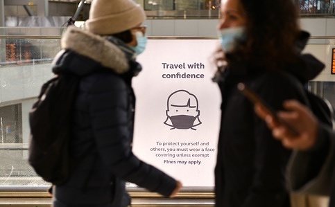 A commuter seen walking past a Wear Face Masks poster, at Waterloo Station in London.
Face coverings in England has become compulsory again in public transport, as well as railway stations.
