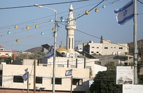 Israeli flags installed by Jewish settlers are seen near a mosque at the entrance to the city of Jenin in the northern West Bank.