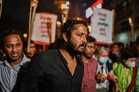 Activists and students hold placards and lit torches as they take part during the procession.
Activists and students take part in a torch procession against the death of writer Mushtaq Ahmed under police custody. Mushtaq was jailed last May under the controversial Digital Security Act (DSA) that criminalize free speech, limiting the freedom of expression in Dhaka, Bangladesh. During torch procession Police officers beat demonstrators and used tear gas shells to disperse protesters.