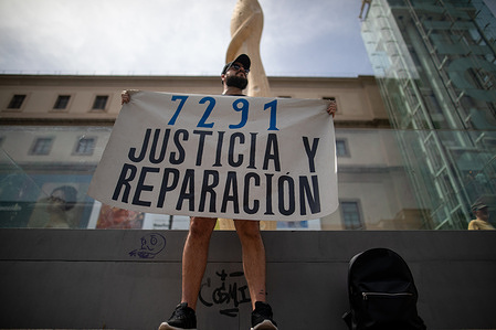 A protester carries a placard during the demonstration. A demonstration is held in tribute to the 7,291 people who died in nursing homes during the pandemic.