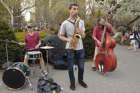 Street musicians perform on the street in Washington Square Park, Manhattan, New York City.