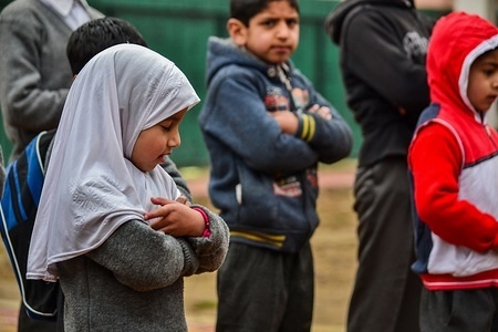 A Kashmiri student prays during morning assembly in their school premises on the first day of the schooling session in Srinagar, Kashmir. The schools and colleges re-opened in Kashmir on Monday after nearly three-month-long winter vacation.