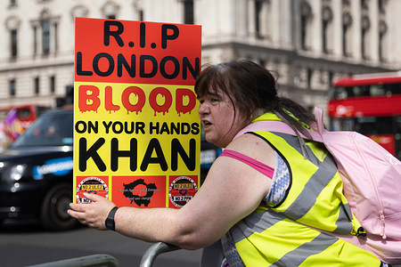 An anti-ULEZ protester holds a placard outside Parliament in London as the ULEZ (Ultra Low Emission Zone) expansion takes effect. Drivers in Greater London are now subject to strict pollution rules; they will have to pay a £12.50 daily fee if their vehicles do not meet required emissions standards.