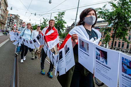 A group of Belarusian protesters hold photos of political prisoners during the demonstration.
The Belarusian community in The Netherlands organized a protest to show their support to all political prisoners and victims of the regime. The protest took place at the Dam Square and after that they walked around the center of Amsterdam. With this protest, they demand to stop the violence against political prisoners in Belarus, against the repression, and for fair democratic elections.