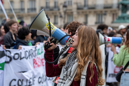 A young French student leads the crowd in a protest song during a Pro-Palestine protest outside the Pantheon in Paris. French high school and university students gathered in front of the Pantheon in Paris to express solidarity with Palestine, denouncing the ongoing violence in Gaza and calling for an end to what they described as genocide. The peaceful pro-Palestinian protest was met with the presence of riot police, who also managed a nearby pro-Israel counter-protest. Flags, signs, and chants filled the air as both sides voiced their perspectives on the current conflict.