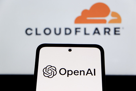 In this photo illustration, the OpenAI logo is seen displayed on a smartphone screen and the Cloudflare logo in the background.