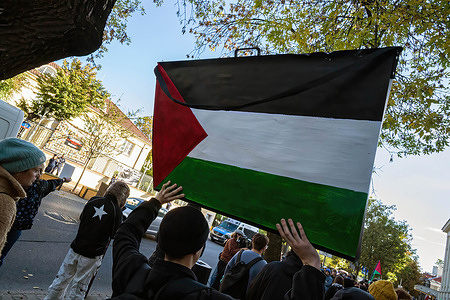 A protester holds a placard with an image of the Palestinian flag. On the morning of the 2nd October, pro-Palestine supporters gathered at the Israeli embassy to protest against Israel's illegal interception and detention of the participants of the Global Sumud Flotilla. With over 40 vessels, the latest Global Sumud Flotilla to provide aid to Gaza and break Israel's naval blockade was one of the largest yet and set out from Barcelona in late August before being intercepted in early October. Among the participants were four Poles, Ewa Jasiewicz, Nina Ptak, Polish MP Franek Sterczewski and Polish resident, Palestinian Omar Faris.