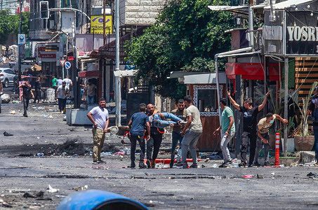 Palestinians help an injured colleague after he was shot on the head by Israeli forces in the Jenin refugee camp. Palestinian health officials said at least 10 Palestinians were killed in Israeli raids and airstrikes. Army spokesman Rear Adm. Daniel Hagari said Israel launched the operation because some 50 attacks over the past year had emanated from Jenin.