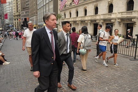 People walk past the New York Stock Exchange in the Financial District in Manhattan, New York City.