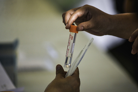 A health worker gives a woman a container to place her swab sample during a COVID-19 testing operation.The country is placed under watch after the Ministry of Health announced the first case of the COVID-19 Delta Variant. El Salvador registers 87,498 positive cases and 2,651 deaths.
