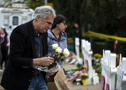 A mourner seen placing flowers on the memorials erected outside of the Tree of Life Synagogue in Squirrel Hill. Members of Pittsburgh and the Squirrel Hill community pay their respects at the memorial to the 11 victims of the Tree of Life Synagogue massacre perpetrated by suspect Robert Bowers on Saturday, October 27.
