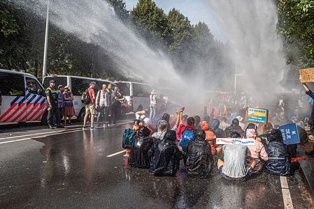 Extinction Rebellion climate activists are being sprayed by a water canon during the non-violent sit-down demonstration. Extinction Rebellion organized a blockade on the A12 motorway in The Hague for 8 days in a row, despite a ban from the municipality. A few hundred demonstrators divided themselves into several groups along the Utrechtsebaan. The 650 arrested demonstrators were taken by bus to the ADO football stadium and released without further action. The action group threatens to repeat these protests indefinably until their demands are met. Among the demonstrators and later arrested too, was the Dutch actress Carice van Houtan.