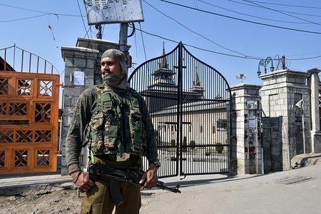 An Indian policeman stands alert outside the historic Grand Mosque during restrictions in Srinagar, Indian administered Kashmir. Authorities imposed restrictions in many parts of Kashmir ahead of Shopian march to stop street protests. The Kashmiri separatists have asked people to march towards Shopian on Wednesday to register the protest against the killing of civilians in army firing.