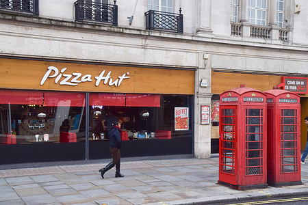 A person walks past the Pizza Hut restaurant in the Strand as the operating company DC London Pie announces the closure of 68 restaurants.