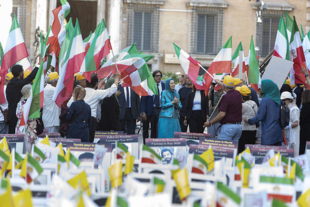 Maryam Rajavi joins Iranian Resistance supporters surrounded by flags and banners honoring fallen protesters during the outdoor memorial. The National Cancer Research Institute (NCRI) organized an exhibition and memorial ceremony at Piazza dei Santi Apostoli in Rome to honor victims of executions and repression in Iran. Maryam Rajavi, President-elect of the NCRI, joined the Iranian diaspora in laying flowers and commemorating the lives of MEK martyrs, including recently executed political prisoners Behrouz Ehsani and Mehdi Hassani.