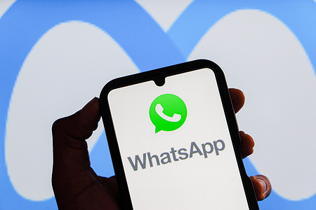 In this photo illustration, a Whatsapp logo is seen displayed on a smartphone screen with Meta AI logo in the background.