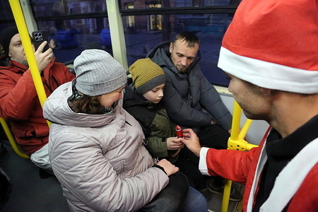 A conductor dressed as St. Nicholas gives sweets to a child on tram route number 7. In honor of St. Nicholas Day, festive trams and trolleybuses decorated with garlands were launched in Odessa. Everyone had free rides in the decorated carriages, and passengers with children received sweets from St. Nicholas. On December 6, Ukrainians celebrate St. Nicholas Day—one of their most beloved children's and family holidays. After the churches adopted the New Julian calendar, the date of the celebration was moved from December 19 to December 6.
