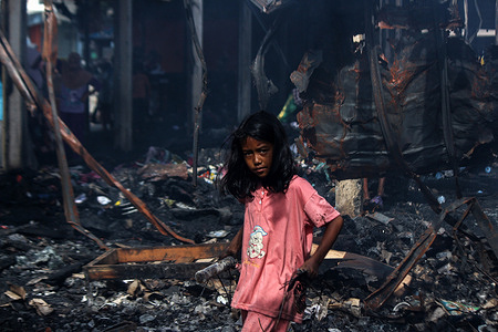 A girl is seen collecting leftover merchandise after a large fire raged the traditional market of Lhokseumawe City, Aceh Province. 
About 200 merchant buildings caught fire in the Lhokseumawe City traditional market, which allegedly originated from electricity, there were no fatalities in the fire.