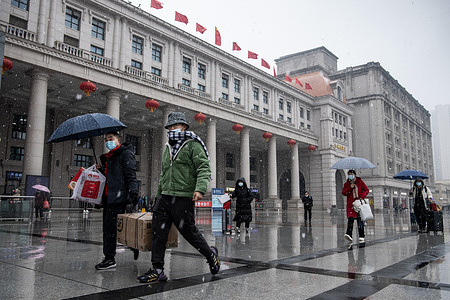 Passengers wearing masks walk in snowfall at the Hankou Railway Station in Wuhan.
A total of 2.8 billion passenger trips are expected during the 40-day 'Chunyun,' or Spring Festival travel rush, which started from January 17 this year. Millions of Chinese will travel home to visit families in mass during the Spring Festival holiday period that begins with the Lunar New Year on February 1.