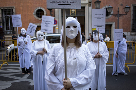 Women wearing masks and white robes hold placards during a demonstration by the Somos Ellas Madrid collective, banners bore the names of the 32 women who have been murdered in Spain so far in 2026. The feminist protest sought to raise awareness about the victims and denounce gender violence.