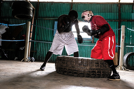 Boxers are seen challenging each other in a boxing match at the local Gym space in Kibera.
Kenya well known for its multiple talents performed by local youths from different life backgrounds. Due to the coronavirus pandemic, not many local and international sports events have been taking place, most sports men and women have been left behind in their trainings, matches, and events that they mostly depended on to sustain themselves. Most youths that depend on the boxing sport as a means of survival and sustainability have resorted to opening up their dark training rooms to begin their early trainings despite the pandemic.