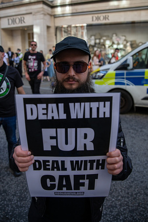 A member of the vegan protest group RAGE, holds a placard during a demonstration. RAGE activists held a vegan protest outside the Louis Vuitton store on New Bond Street, London, opposing the use of animal products in fashion. Police were present in large numbers and carried out searches on several individuals. The protest caused disruption in the area, with officers monitoring the crowd and maintaining access to the store.