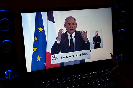 French Prime Minister Francois Bayrou seen on a computer screen during a press conference. French Prime Minister François Bayrou defended his €44 billion austerity budget proposal for the 2026 budget during a televised press conference.