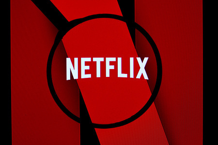 In this photo illustration, the Netflix logo is seen through a magnifying glass on a computer screen.