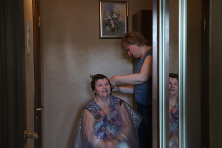 Oksana, professional hair stylist gives a haircut to Liudmila her mother-in-law at her house as all barbershops were ordered to close in an attempt to prevent the spread of coronavirus (COVID-19)