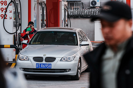 A man is seen filling his car with petrol at a petrol station. The National Development and Reform Commission (NDRC) announced a record hike of 1,160 yuan per ton in gasoline prices, triggered by soaring global oil prices amid the Middle East conflict. These images capture the widespread anxiety as fuel costs hit an all-time high despite government subsidies.