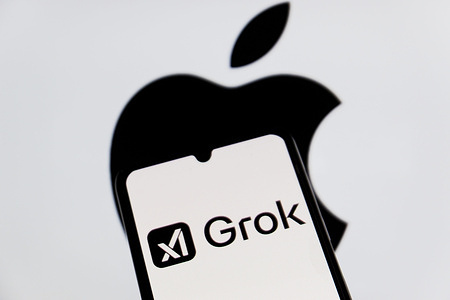 In this photo illustration, a Grok AI logo is seen displayed on a smartphone with an Apple logo in the background.