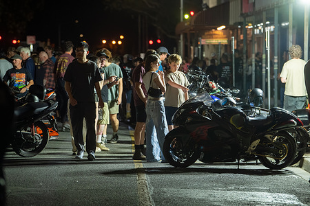 People gather around motorcycles during the Red CentreNATS street party outside Bojangles Saloon. One hundred and three motorcyclists ride through Bojangles Saloon as crowds gather for the Bikes Through the Bar event and Show and Shine street party during Red CentreNATS in Alice Springs. The annual automotive festival brings together cars, motorcycles, cruising, competitions and motoring events across Alice Springs.