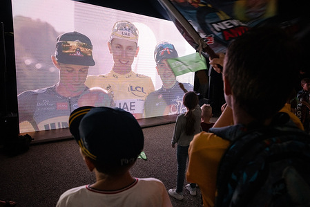 Young fans watch a public screening of the final stage of Tour de France during a public celebration of Tadej Pogacar's second victory in his home town of Komenda, Slovenia. Hundreds of fans of Slovenian cyclist Tadej Pogacar celebrated his second consecutive Tour de France victory at a public screening of the final stage in his home town of Komenda, Slovenia, where they also decorated the town's roundabout and painted it yellow.