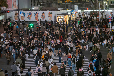 A wide view shows crowds moving through Shibuya Crossing in Tokyo, with multiple crosswalks filling simultaneously beneath bright commercial signage in the Shibuya district. Shibuya is a major commercial and entertainment district in Tokyo, known for its busy streets, youth culture, and the landmark Shibuya Crossing. The area also features Shibuya Sky, an observation deck offering panoramic views of the city and surrounding landmarks.