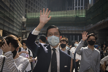 A man makes a gesture about the 5 demands during a march.
Thousands of office workers and masked protesters clash with police in one of the most violent days for the financial hub since the protests began five months ago, a police officer shot a masked protester and another man was doused in fuel and set on fire. Despite the controversial extradition bill which originally sparked the protests being formally withdrawn, protesters continue to call on Chief Executive Carrie Lam to meet their remaining demands which includes complete universal suffrage, an independent investigation into police brutality, retraction of the word ‘rioting’ to describe the protests, and dropping all charges against arrested protesters.