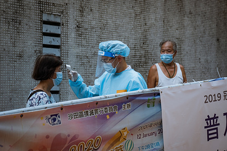 A medical staff checks the body temperature of a woman during the voluntary mass-testing programme for coronavirus.
Hong Kong has begun a voluntary mass-testing programme for coronavirus as part of a strategy to break the chain of transmission in the city’s third outbreak of the disease.