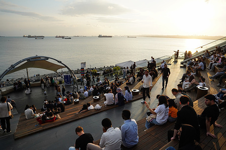 People sit along the coast of Florya in Istanbul, overlooking the Sea of Marmara.