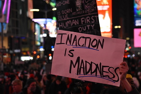 A protester holds a placard that says "Inaction is madness" during the demonstration. Tyre Nichols died on January 10, 2023, three days after five officers from the Memphis Police Department in Tennessee, United States beat him with batons, tasered and kicked him during a traffic stop on January 7, 2023. Protesters hold up placards and gather in Times Square.