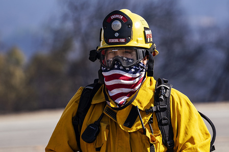 A firefighter wears a bandana with the American flag during the Easy Fire near the Ronald Reagan Presidential Library in Simi Valley, California. The fire spread quickly due to strong Santa Ana winds with wind gusts reaching up to 70 mph in some areas. The National Weather Service issued a rare extreme red flag warning to the greater Los Angeles area. The fire prompted mandatory evacuations.
