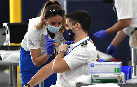 A nurse gives a crew member from the Carnival Liberty cruise ship a shot of the Johnson and Johnson COVID-19 vaccine at Port Canaveral, the first U.S. port to sponsor COVID-19 vaccine distribution to port workers and vessel crew members. 
After all sailings were suspended in March 2020 due to the coronavirus pandemic, the ship docked at the port to enable 109 crew members to be vaccinated at the one-day clinic in preparation for the expected resumption of cruises in July 2021.