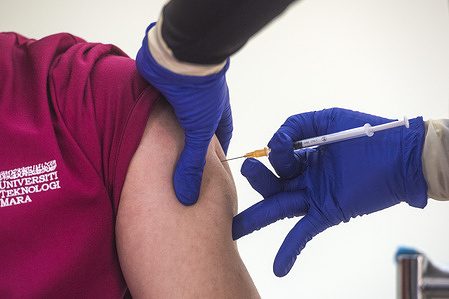 A health worker administers a syringe with a dose of the Pfizer-BioTech Covid-19 vaccine at the UiTM Hospital in Sungai Buloh. 
The Malaysia government says 500,000 front liners of the country nationwide are set to receive the first dose of the Covid-19 vaccine in the first quarter of this year.