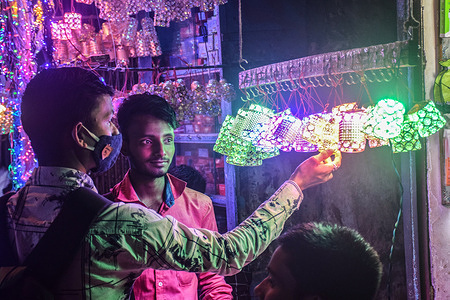 A man wearing a face mask buys lights at a shop.
The popular Hindu festival "Diwali" is coming very soon. Diwali is also called a festival of lights. Many Hindus celebrate Diwali as Kali puja in India.