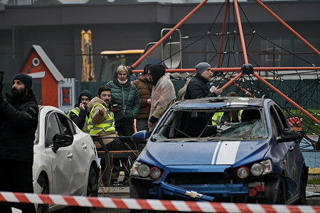 People walk past damaged cars in a yard of an apartment building hit by a Russian airstrike. Local authorities reported dozens of victims of the Russian night attack in Kyiv on the night of November 29, who are currently at city hospitals. According to preliminary information, two people died. The main direction of the Russian army’s strikes is the energy infrastructure of the Kyiv region. Also, destruction of civilian infrastructure and fires due to debris hits were recorded in several residential districts in Kyiv. Part of the capital was left without electricity. Emergency rescue operations and elimination of the consequences of the Russian attack are ongoing at all locations.