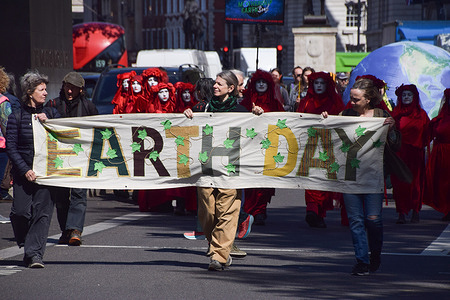 Climate activists march with banner in Whitehall during a demonstration on Earth Day, an annual worldwide event supporting the protection of planet Earth.